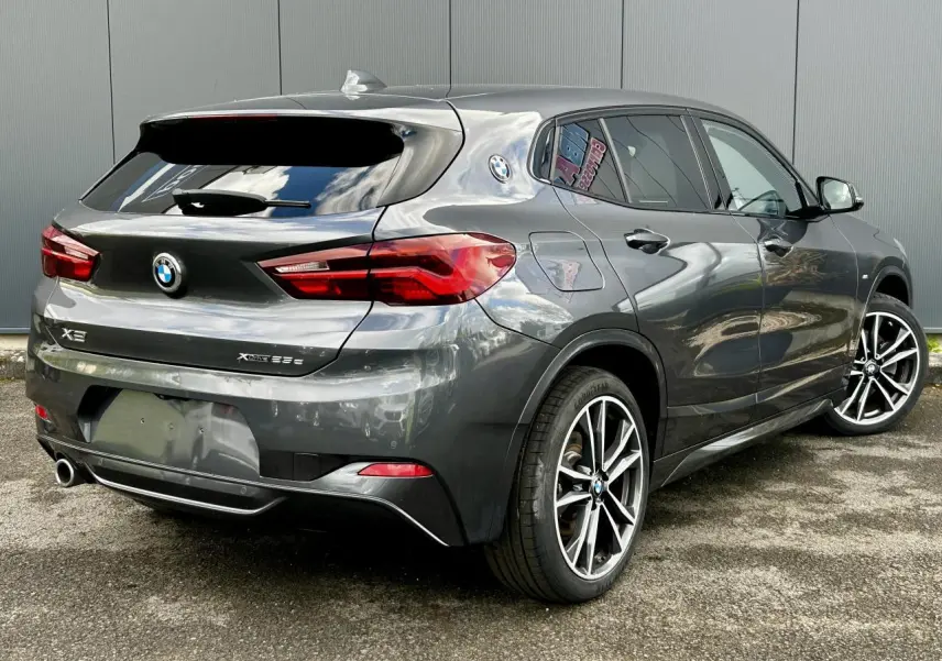 BMW X2 F39 xDrive 25e gris Mineral vue 3/4 arrière droit avec jantes alliage bicolores et hayon fermé