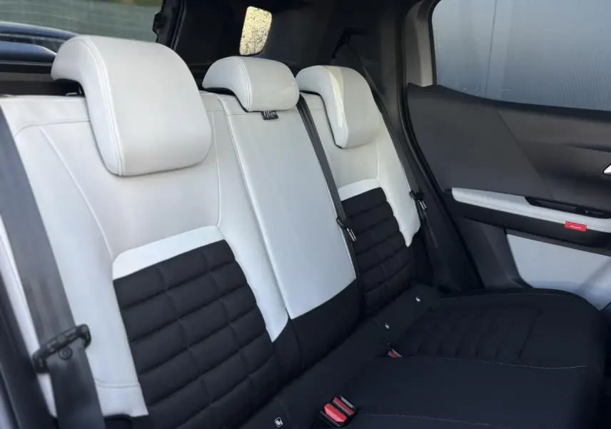 Vue latérale des sièges arrière bicolores noir et blanc du Citroën C3 Aircross 2025 avec garniture textile et appuis-tête intégrés.