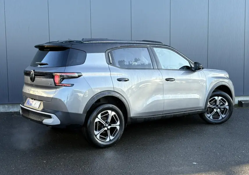 Vue 3/4 arrière droite d'un Citroën C3 Aircross gris Mercury avec toit noir et jantes alliage 17 pouces.