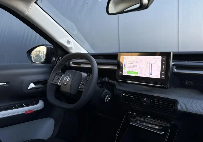 Intérieur du Citroën C3 Aircross 2025 vu côté conducteur, avec tableau de bord noir et écran tactile GPS.