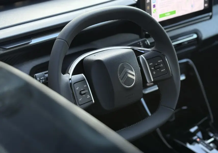 Volant multifonctions noir avec logo Citroën, planche de bord et écran tactile du Citroën C3 Aircross 2025.