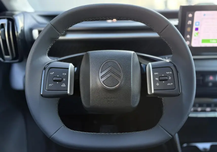 Volant multifonctions noir de Citroën C3 Aircross 2025, avec logo double chevron et commandes intégrées.
