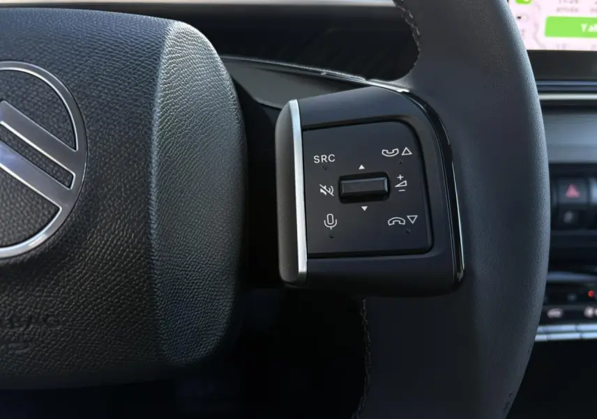 Gros plan sur les commandes multifonctions du volant noir du Citroën C3 Aircross gris Mercury 2025.