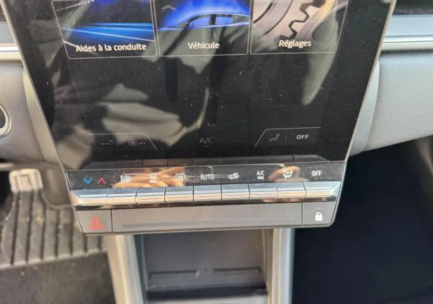 Vue rapprochée du tableau de bord numérique et des commandes tactiles de climatisation du Renault Captur II rouge flamme.