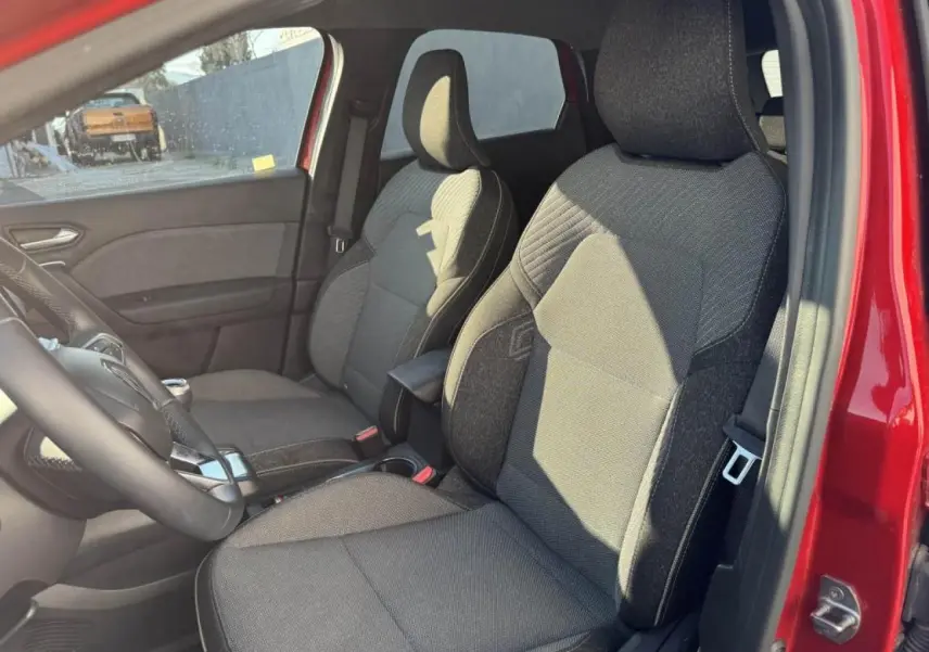 Vue intérieure côté gauche des sièges avant gris foncé du Renault Captur II rouge flamme avec accoudoir central.