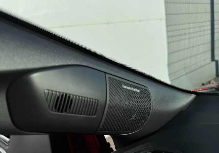 Gros plan sur l'enceinte Harman Kardon côté droit du tableau de bord du Renault Captur II Rouge Flamme toit noir.