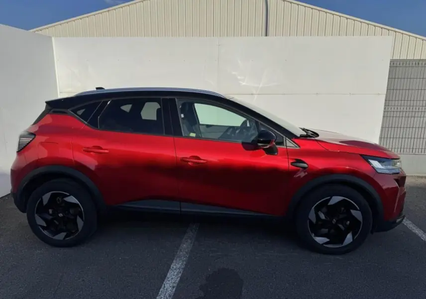 Vue de profil côté gauche du Renault Captur II rouge flamme avec toit noir et jantes noires en aluminium.