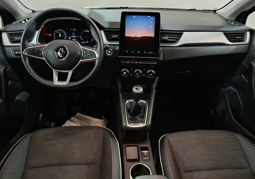 Intérieur du Renault Captur Techno TCe 90 2024, vue frontale du tableau de bord avec écran tactile vertical et boîte manuelle.