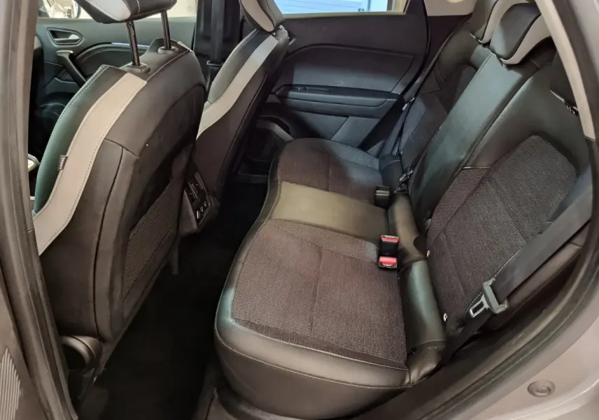 Vue côté droit de la banquette arrière noire et grise du Renault Captur Techno TCe 90 2024, intérieur spacieux et moderne.