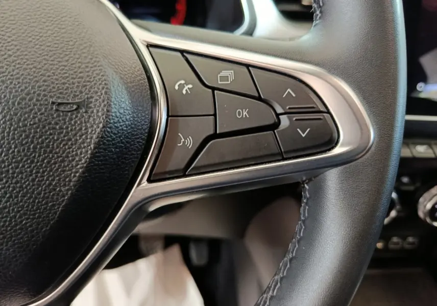 Gros plan sur les commandes du volant en cuir noir du Renault Captur techno TCe 90 2024, boutons multifonctions visibles.