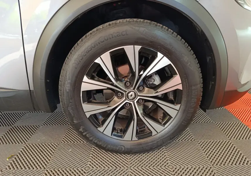 Gros plan sur la roue avant droite du Renault Captur gris foncé, mettant en valeur la jante alliage au design moderne.