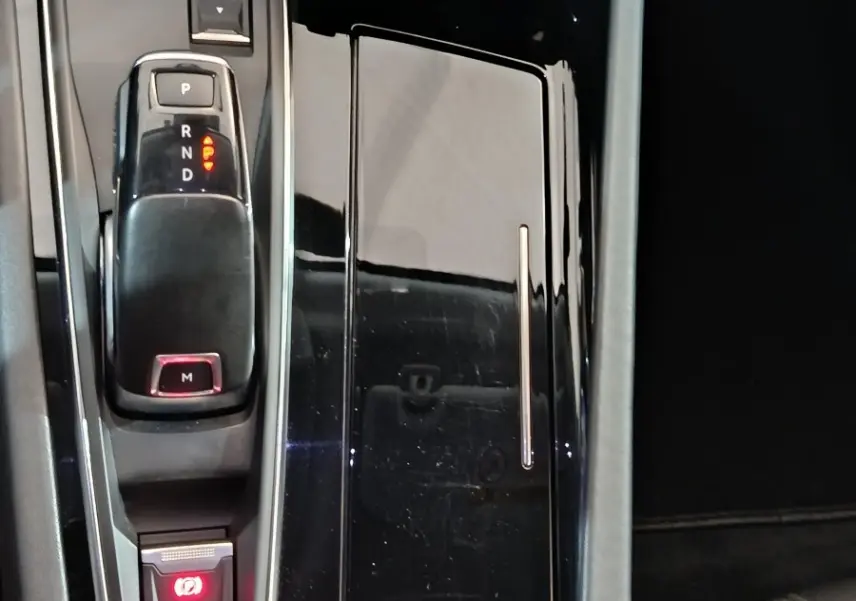 Vue plongeante sur la console centrale noire brillante de la Peugeot 508 BlueHDi 130, avec levier de vitesse et bouton start.