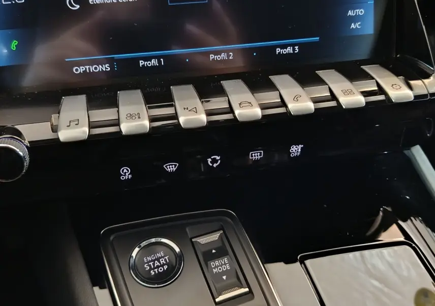 Gros plan sur la console centrale noire du Peugeot 508 gris clair, avec boutons piano et démarrage moteur visible.