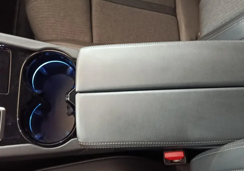 Gros plan sur la console centrale gris foncé avec porte-gobelets éclairés en bleu dans une Peugeot 508 2020.