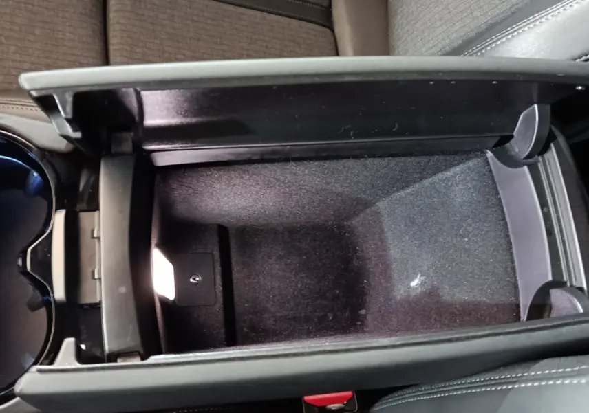 Vue rapprochée de la console centrale ouverte avec rangement intérieur noir du Peugeot 508 gris clair 2020.