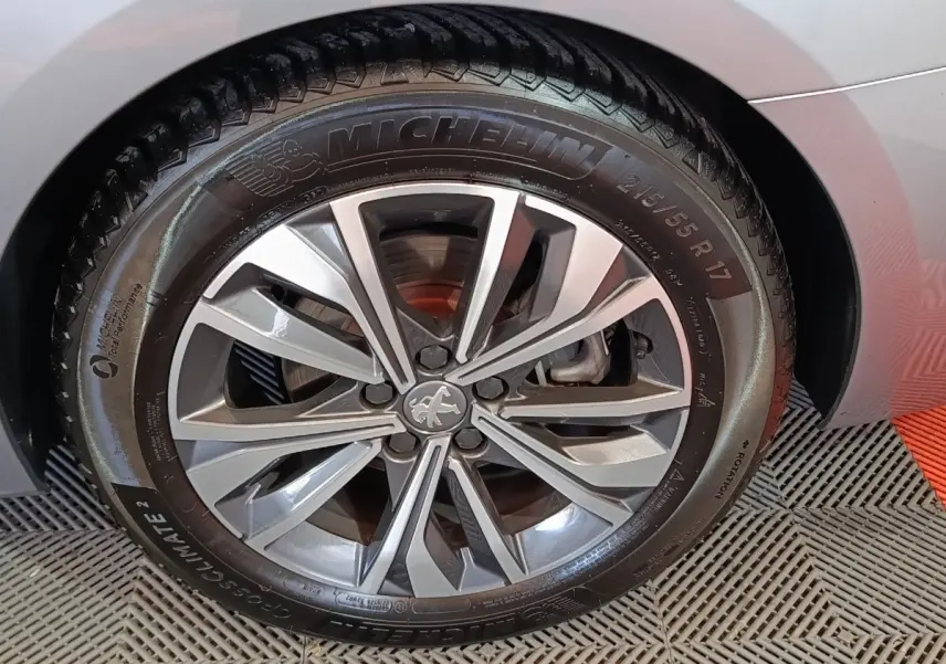 Gros plan sur la roue avant gauche gris clair d'une Peugeot 508 BlueHDi 130 avec jante alliage et pneu Michelin.