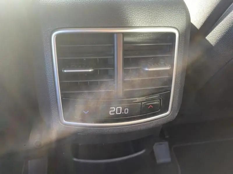Gros plan sur la sortie d’air arrière avec réglage de température digitale à 20°C dans un KIA Sportage gris Eclipse Métal.