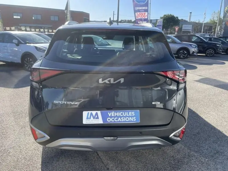 Vue arrière d'un KIA SPORTAGE gris Eclipse métal 2023 avec feux arrière fins et logo KIA moderne visible.