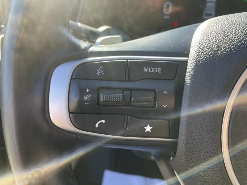 Gros plan sur les commandes multifonctions noires à gauche du volant du Kia Sportage gris Eclipse Metal 2023.