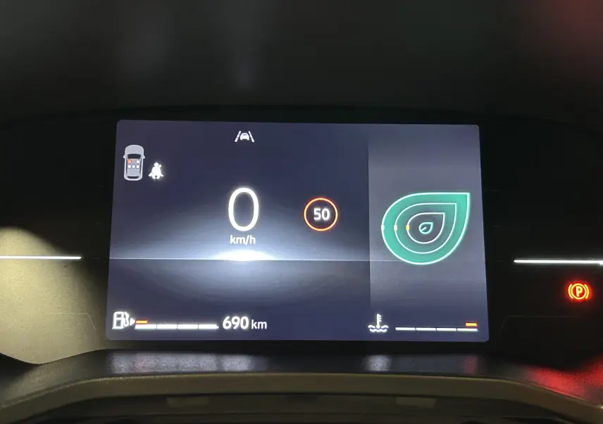 Tableau de bord numérique de Renault Clio V blanc, affichant 0 km/h, limite 50 km/h et autonomie 690 km.