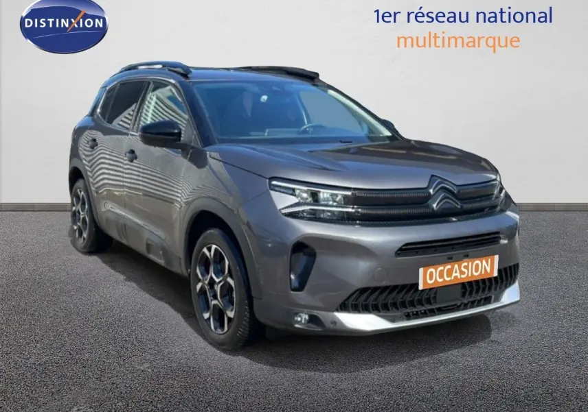 Citroën C5 Aircross gris platinium métal en 3/4 avant droit, avec jantes stylisées et calandre distinctive.