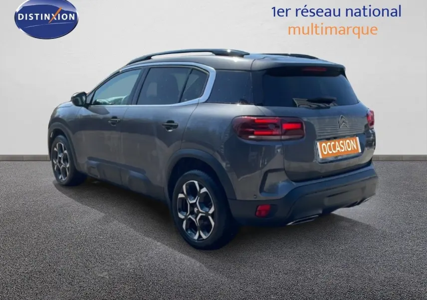 Vue 3/4 arrière droite du Citroën C5 Aircross gris platinium métal avec jantes bi-ton et feux LED distinctifs.