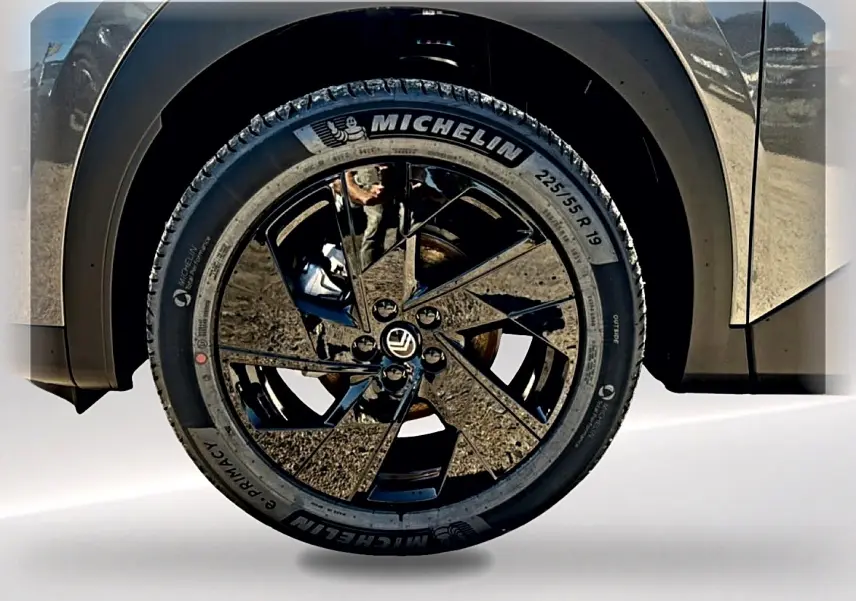 Gros plan sur la roue avant droite du Citroën C5 Aircross gris platinium avec jante alliage noire brillante.