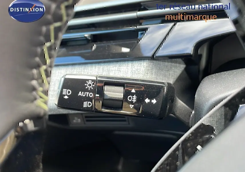 Le levier de commande des feux et clignotants du Peugeot 3008 hybride 2025, avec tableau de bord en arrière-plan.