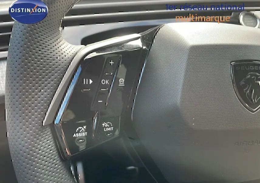 Gros plan sur le volant perforé noir du Peugeot 3008 2025 avec commandes intégrées et logo lion central.