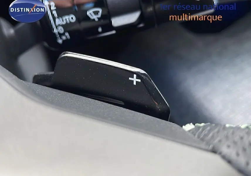 Gros plan sur la palette de changement de vitesse + du Peugeot 3008 hybride 2025, intérieur noir.