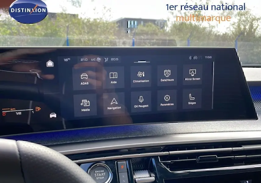 Vue intérieure du tableau de bord du Peugeot 3008 hybride 2025, écran tactile central avec menu de commandes digitales.