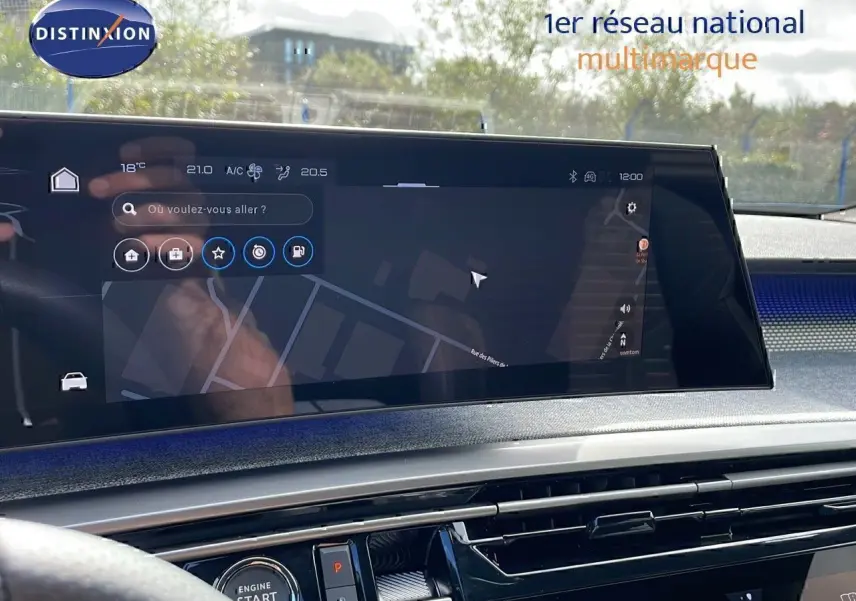 Écran tactile central affichant la navigation dans l'habitacle du Peugeot 3008 hybride 2025, volant partiellement visible.