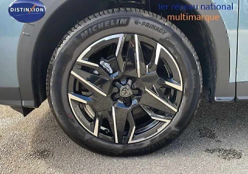 Gros plan sur la roue avant gauche du Peugeot 3008 bleu Ingaro métal avec jante alliage noire et argentée.
