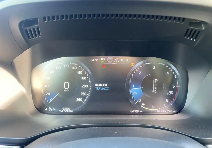 Tableau de bord numérique du Volvo XC60 blanc 2019, affichant vitesse, régime et radio TSF Jazz.