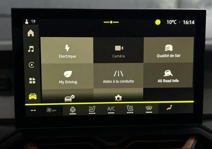 Écran tactile central du tableau de bord du Dacia Duster blanc glacier, affichant les options d’aides à la conduite et climatisation.