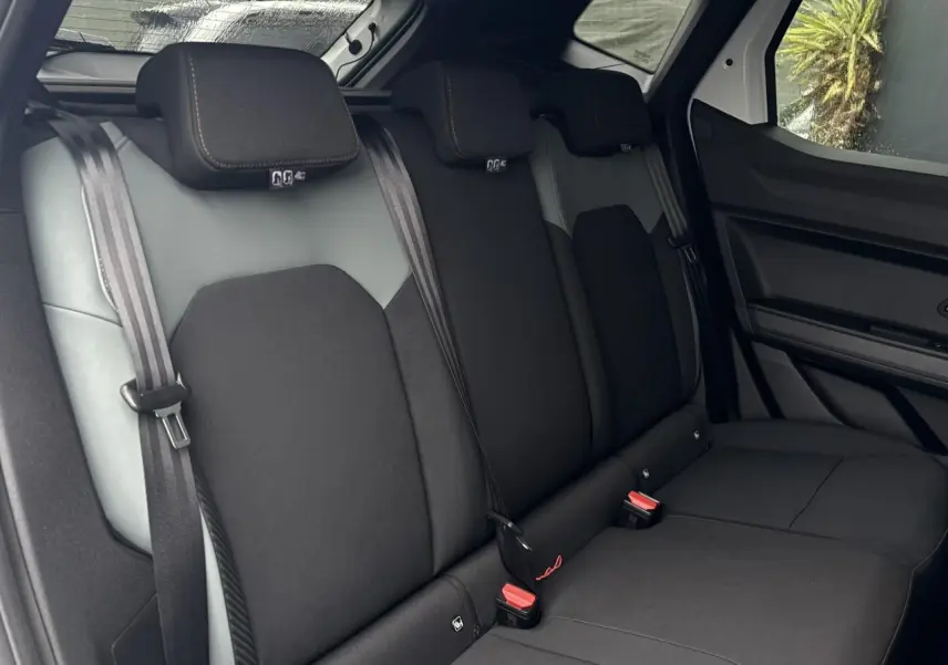 Vue intérieure sur la banquette arrière noire du Dacia Duster 2026, avec ceintures de sécurité et appuie-têtes visibles.