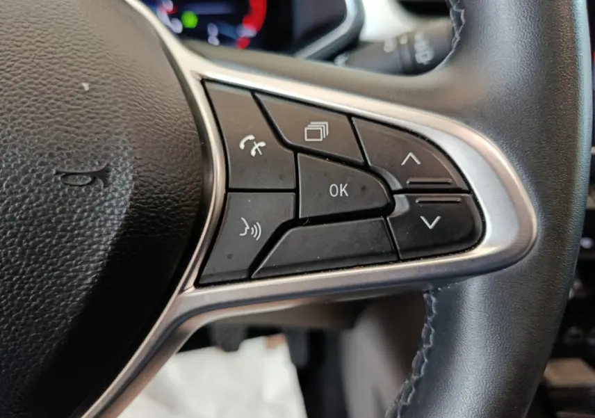 Gros plan sur les commandes multifonctions côté droit du volant noir du Renault Captur rouge Techno TCe 90 2024