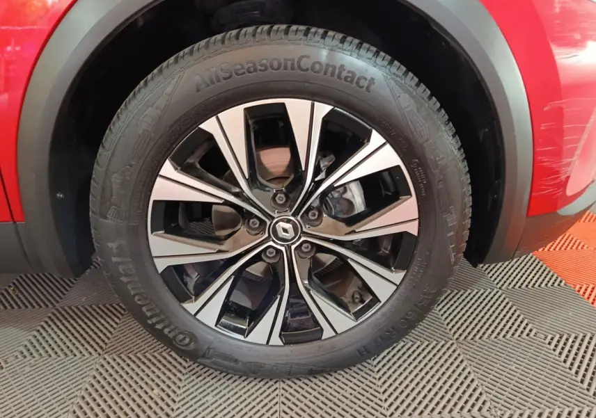 Gros plan sur la roue avant droite du Renault Captur rouge 2024 avec jante alliage bicolore et pneu Continental.