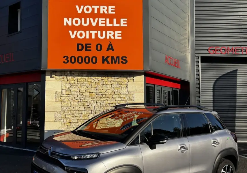 Citroën C3 Aircross gris clair vue 3/4 avant droit, avec toit noir et jantes alliage distinctives.