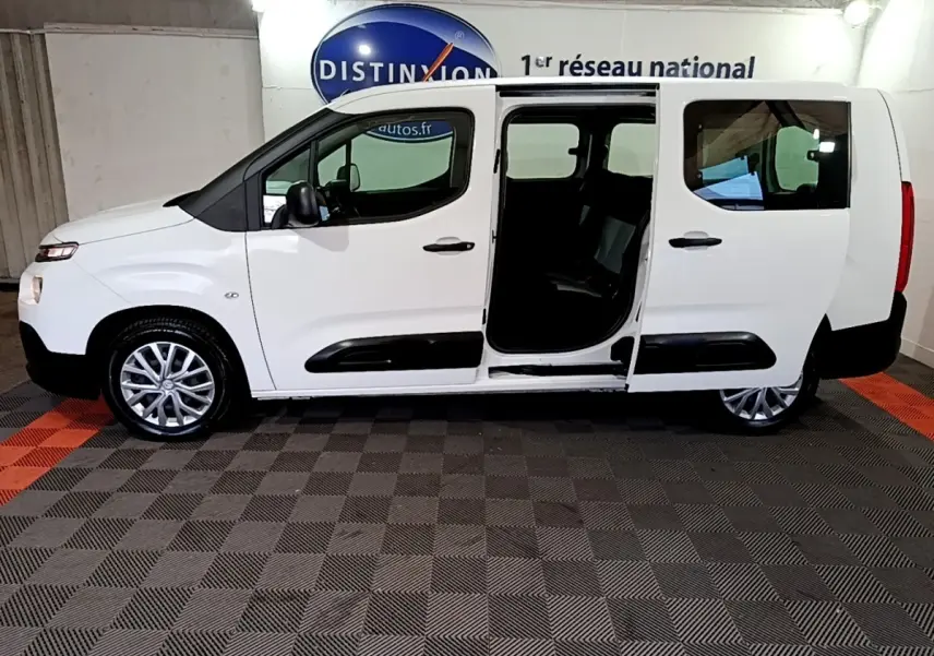 Vue latérale droite d'un Citroën Berlingo XL blanc 2019 avec porte coulissante ouverte en intérieur showroom.