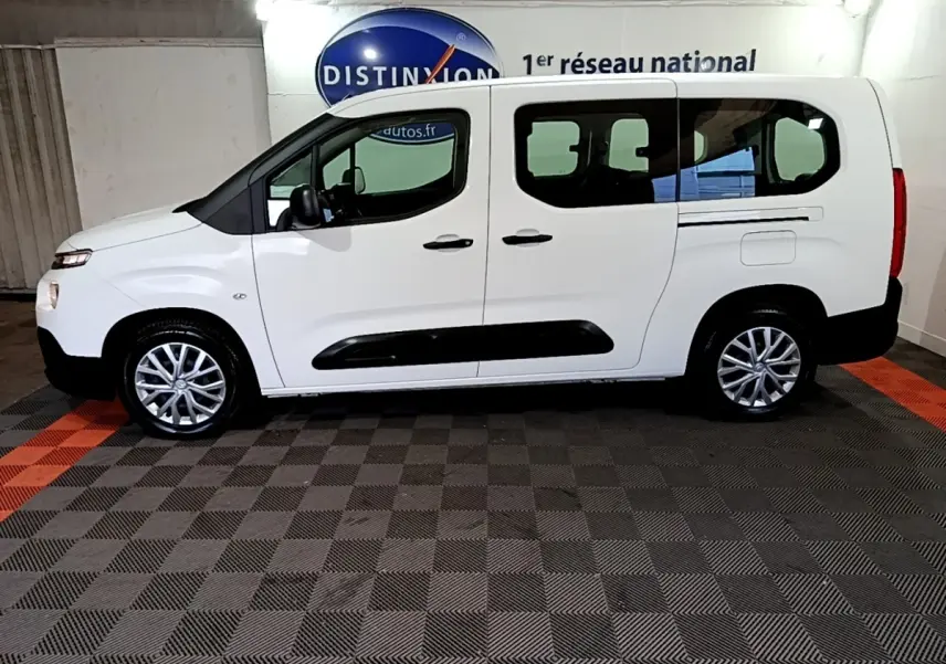 Vue latérale droite d'un Citroën Berlingo XL blanc, avec vitres teintées et protections noires sur les portes.