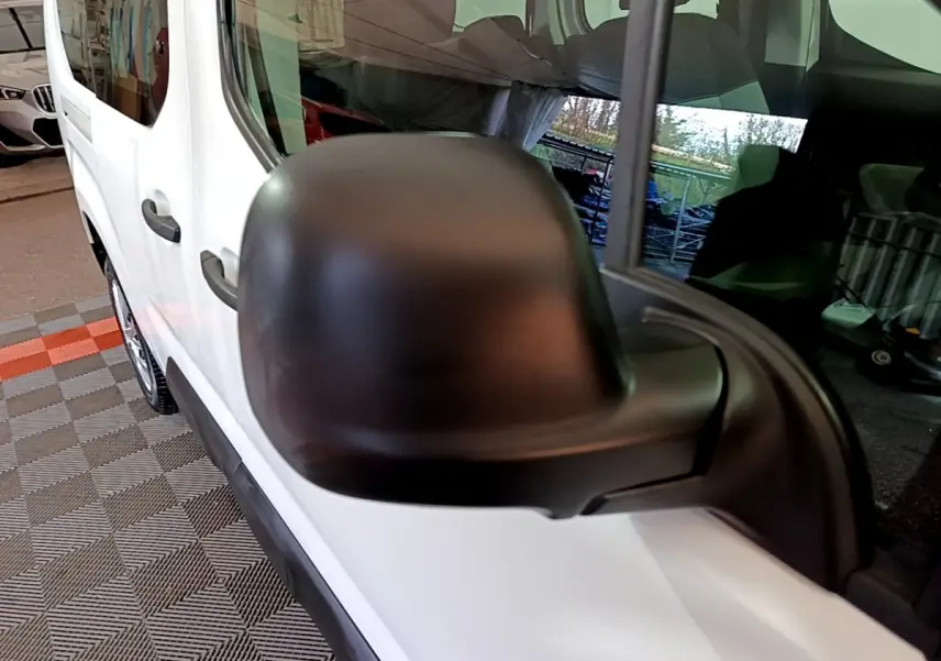 Gros plan sur le rétroviseur côté conducteur noir du Citroën Berlingo blanc, vue latérale avant gauche.