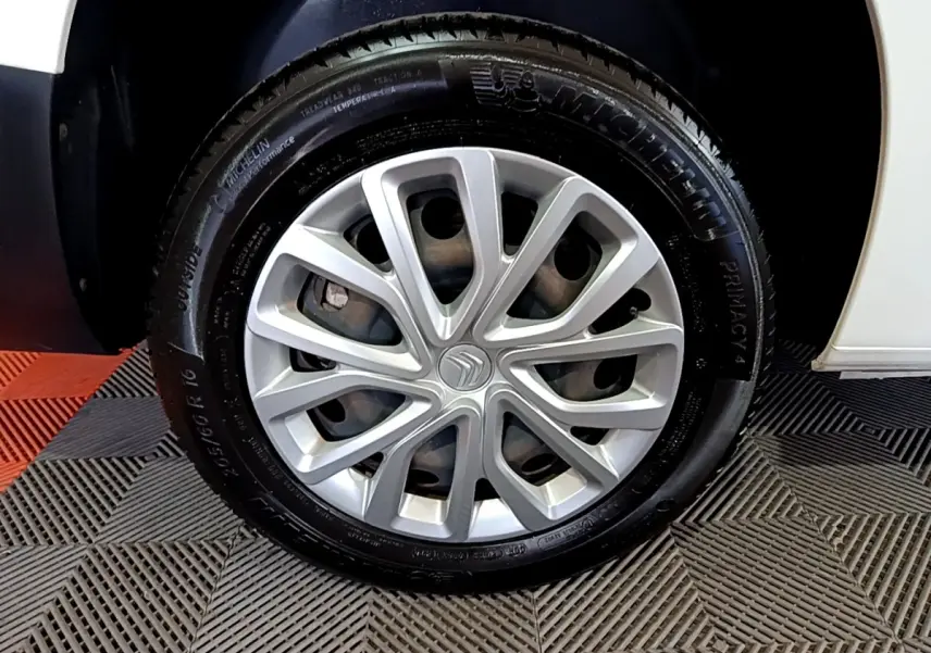 Gros plan sur la roue avant droite de la Citroën Berlingo XL blanche, mettant en valeur la jante en alliage et le pneu Michelin.