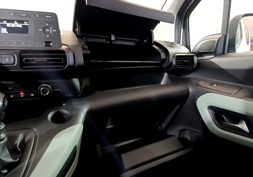 Vue intérieure côté passager du tableau de bord noir et gris avec boîte à gants ouverte du Citroën Berlingo XL blanc 2019.