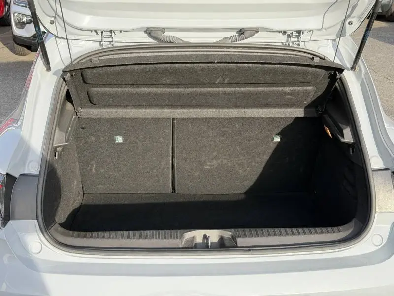 Coffre ouvert vu de l'arrière d'une Renault Clio 1.6 E-Tech gris Rafale, montrant l'espace de rangement vide.