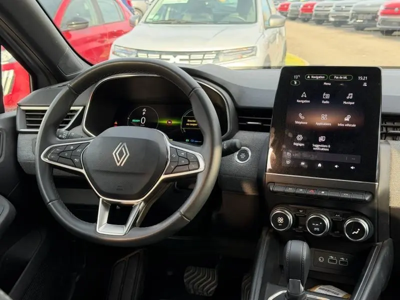 Vue intérieure centrée sur le volant et l’écran tactile vertical du tableau de bord de la Renault Clio 1.6 E-Tech hybride.