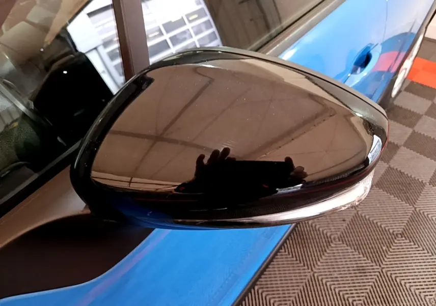Rétroviseur noir côté gauche en gros plan sur Citroën C3 bleu, avec clignotant intégré visible.