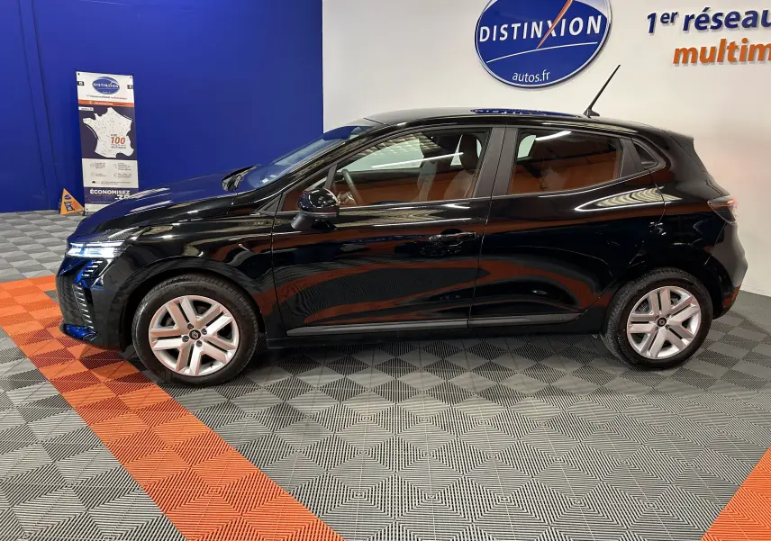 Profil latéral gauche d'une Renault Clio V noire, en intérieur, avec jantes alliage et vitres teintées.