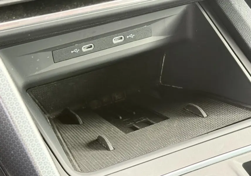 Gros plan sur la console centrale du SEAT Leon 2025, montrant les ports USB-C et le chargeur à induction noir.