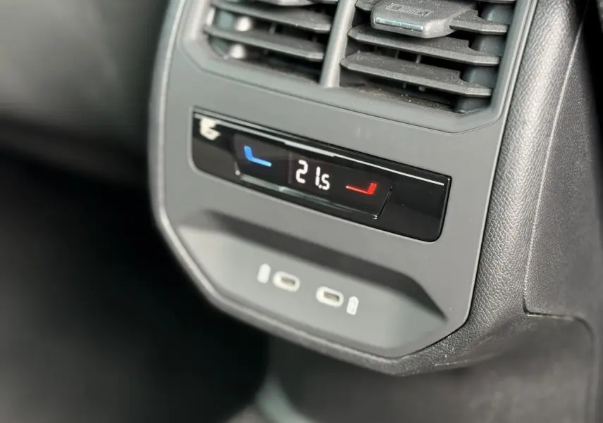Détail du panneau de climatisation arrière avec affichage digital et ports USB-C dans une SEAT Leon blanche.